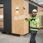 ADU Now LA builder carrying construction materials for backyard ADU installation in Los Angeles